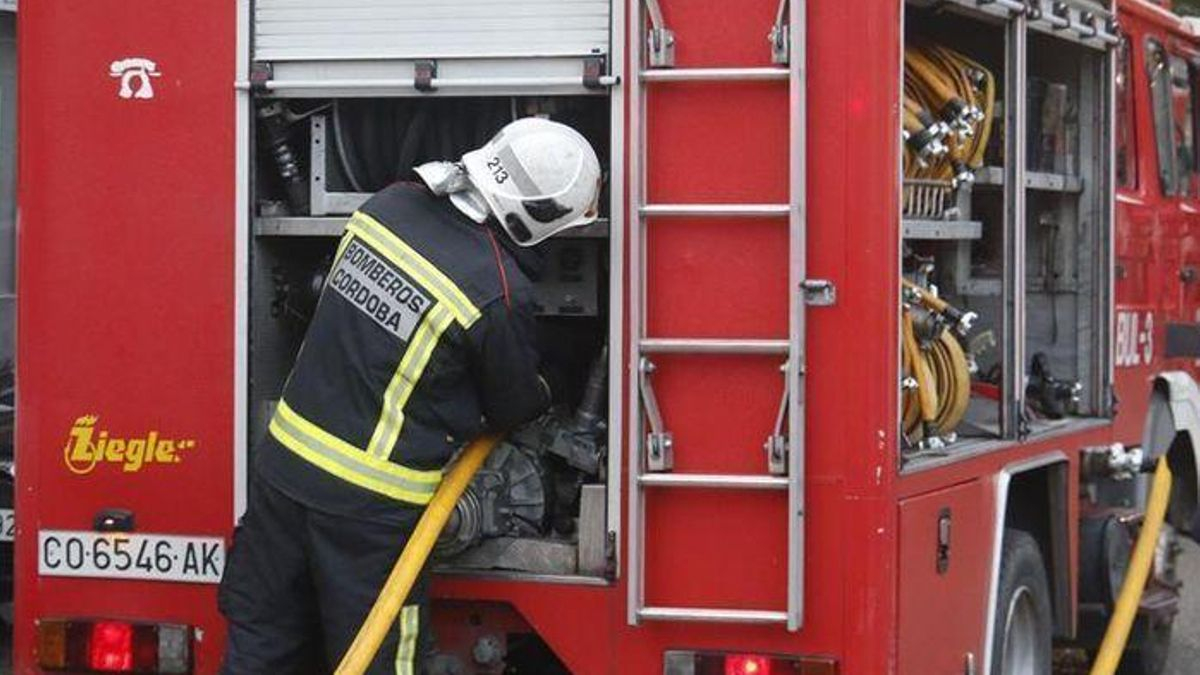 Un bombero prepara una manguera para intervenir en un incendio.