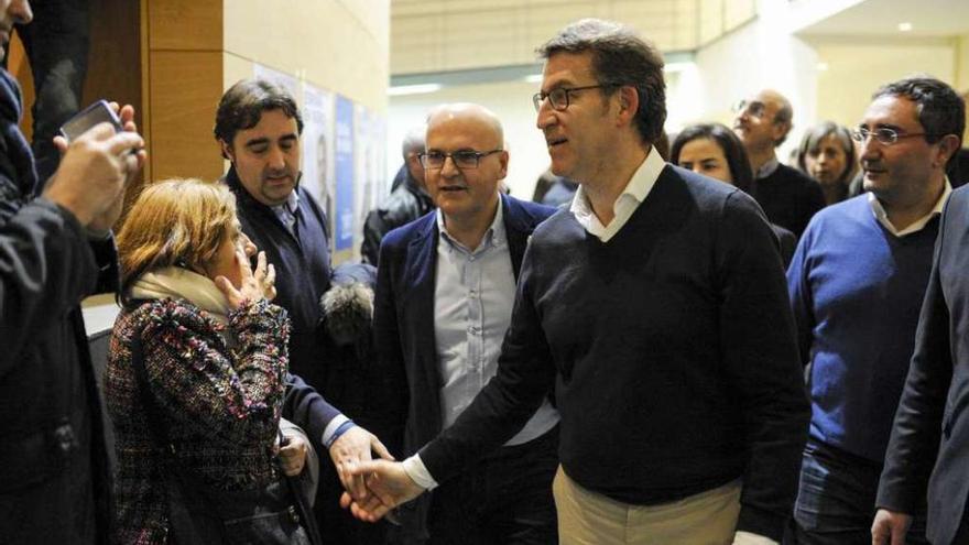 Feijóo, junto al Baltar, saluda a un hombre, ayer antes del mitin en O Carballiño.