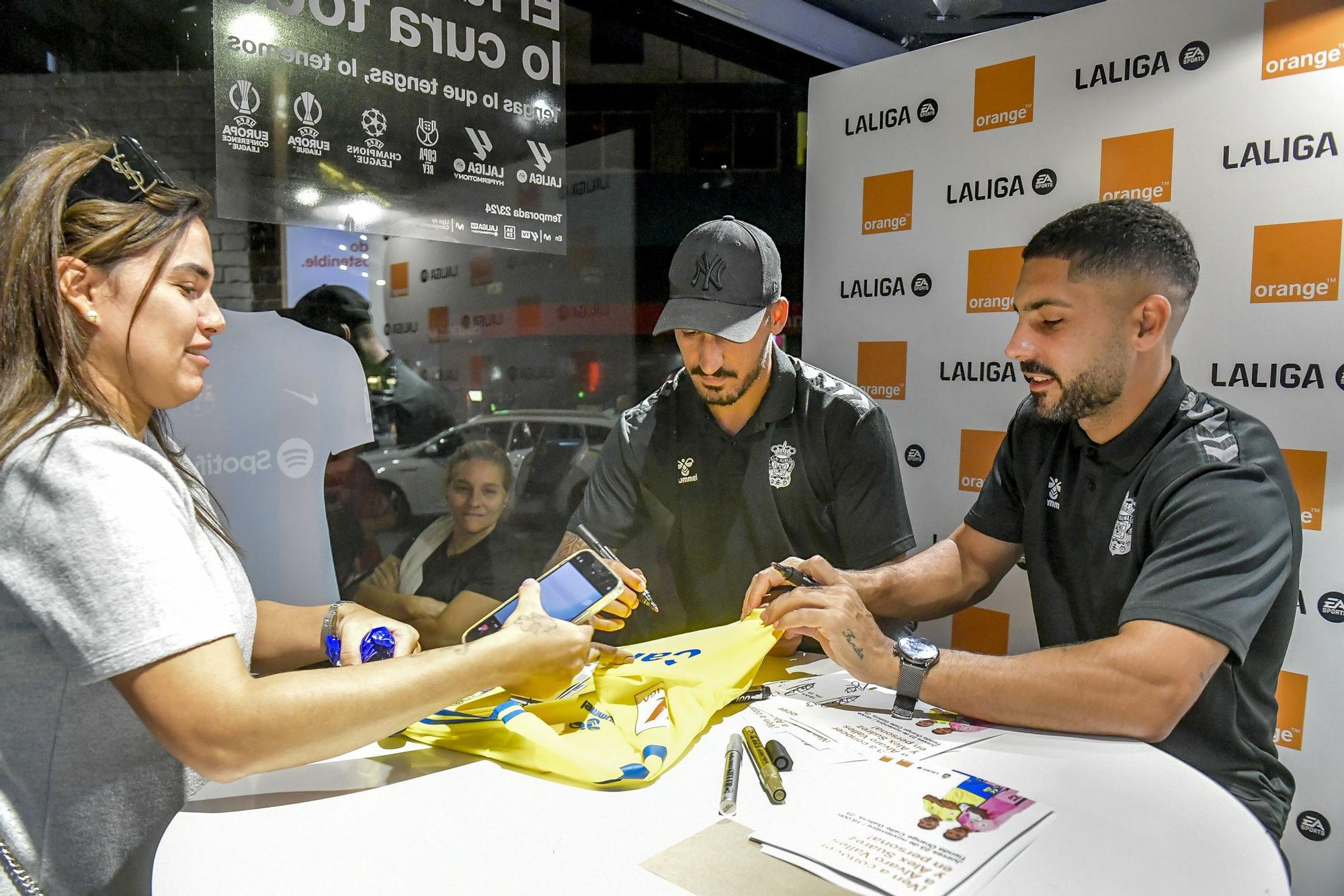 Álex Suárez y Álvaro Valles atienden a los aficionados en la Tienda Orange de la calle Galicia