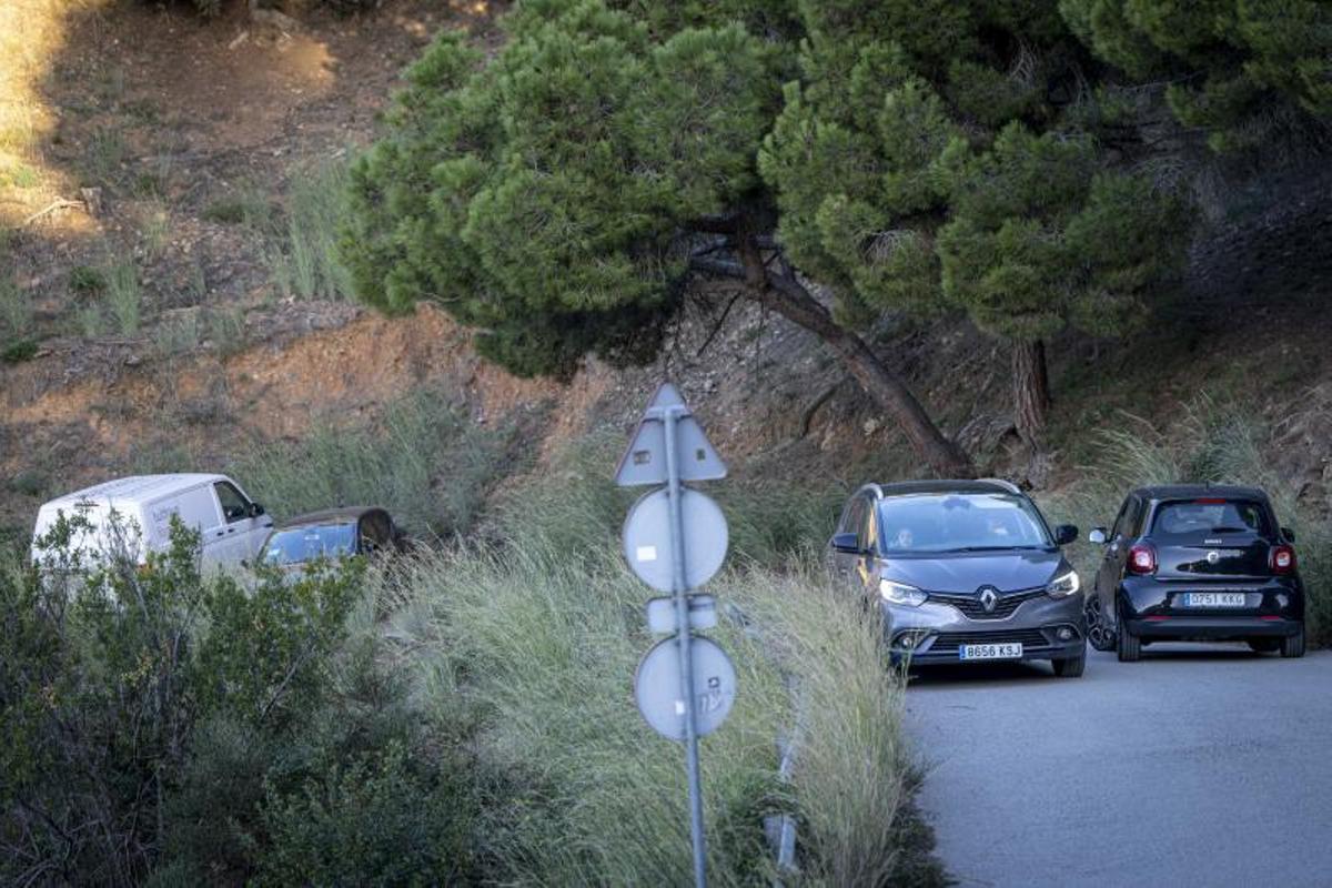 Dos coches reducen la velocidad para cruzarse en un punto estrecho de la parte de la vía que es solo para vecinos.