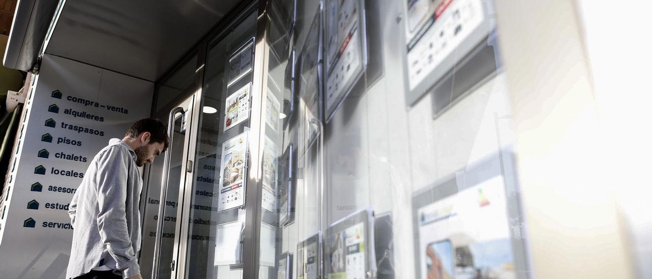 Un joven observa los precios de los pisos de alquiler en una inmobiliaria de València, ayer.