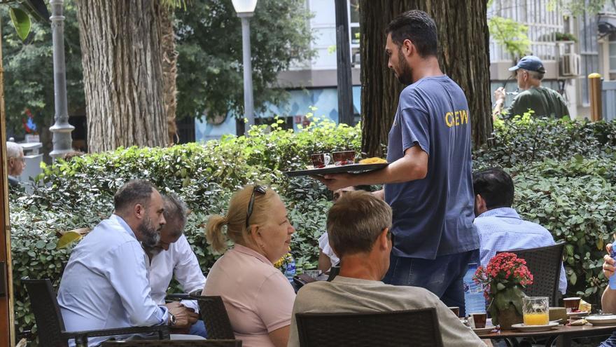 Un camarero atiende a los clientes de una terraza en el centro de Alicante. | PILAR CORTÉS