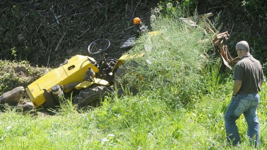 Vista de un tractor en una finca tras un vuelco que atrapó al conductor.