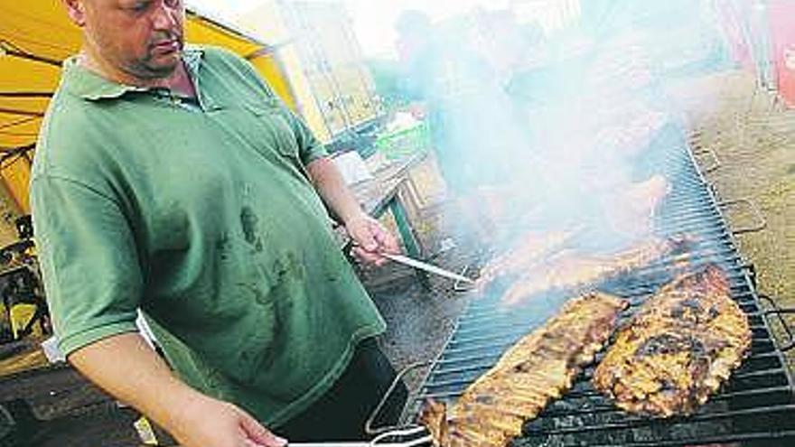 Uno de los parrilleros preparando los costillares.