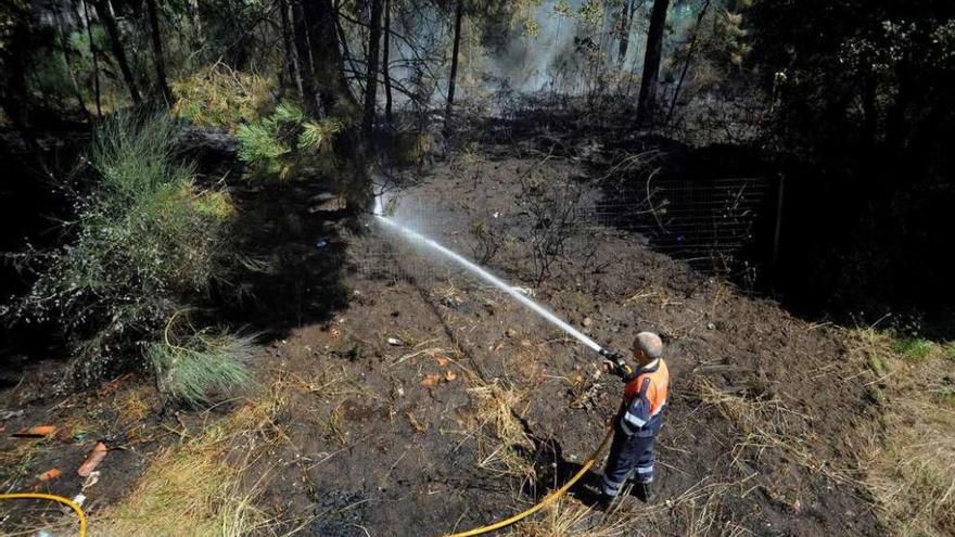 Los equipos de extinción controlan el fuego cuando ya había entrado en la propiedad de Abal. // Iñaki Abella