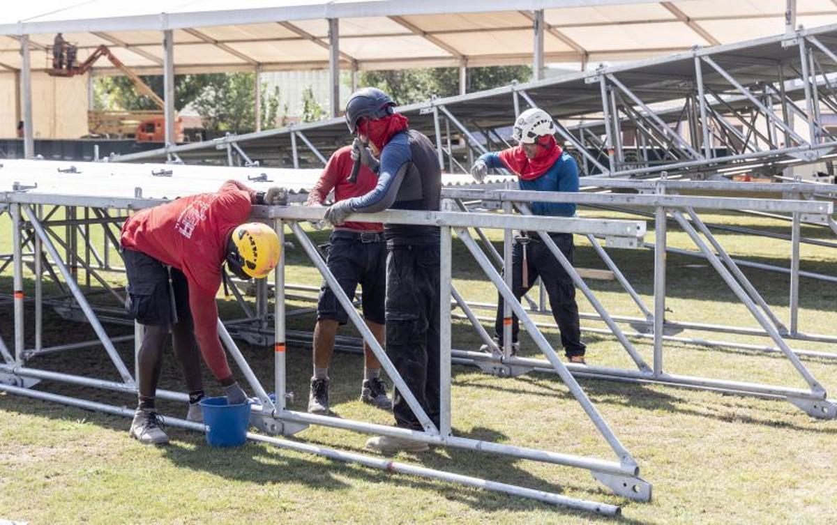 Operarios trabajan en el techo de los dos escenarios principales del Leyendas del Rock
