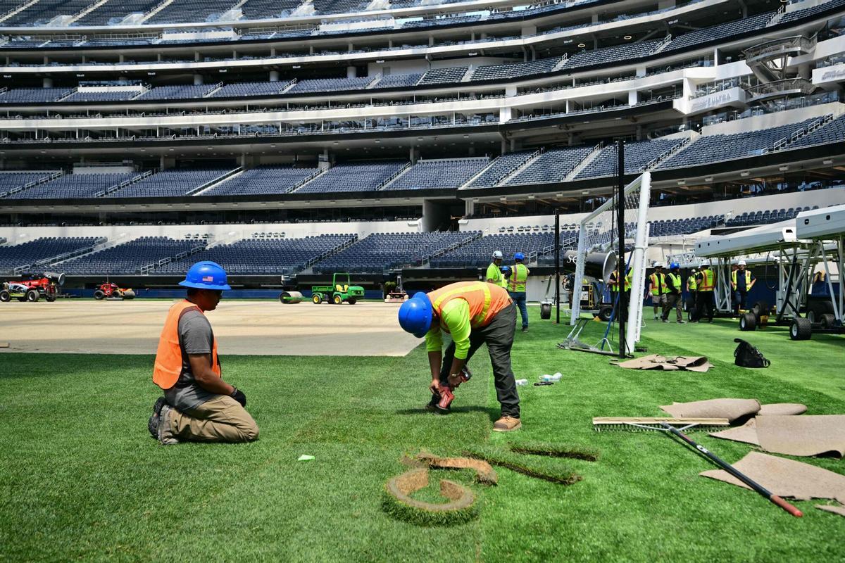 Los trabajadores instalan césped en el campo en el SoFi Stadium en Inglewood, California, antes de su cambio de nombre temporal al Estadio de Los Ángeles para la Copa del Mundo el 13 de mayo de 2026.