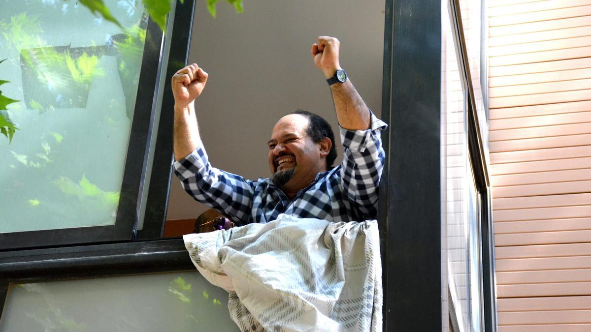 El hombre que ha podido volver a su vivienda celebra desde la ventana