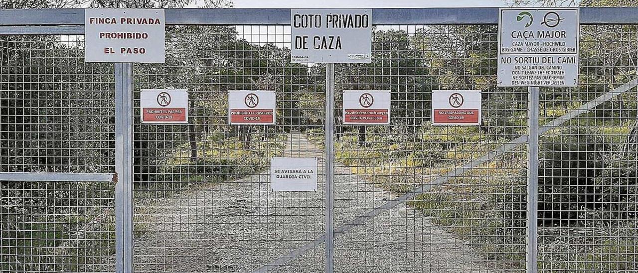 Imagen de la barrera que limita el paso al camino de Cala Figuera, con carteles que amenazan con llamar a la Guardia Civil.