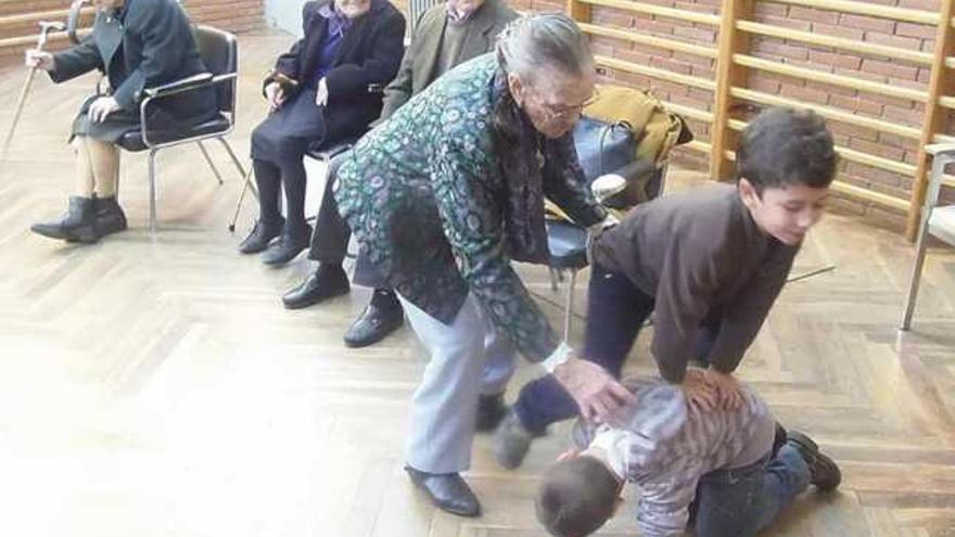 Una mujer  enseña a los pequeños uno de los juegos con los que se entretenía en su niñez.