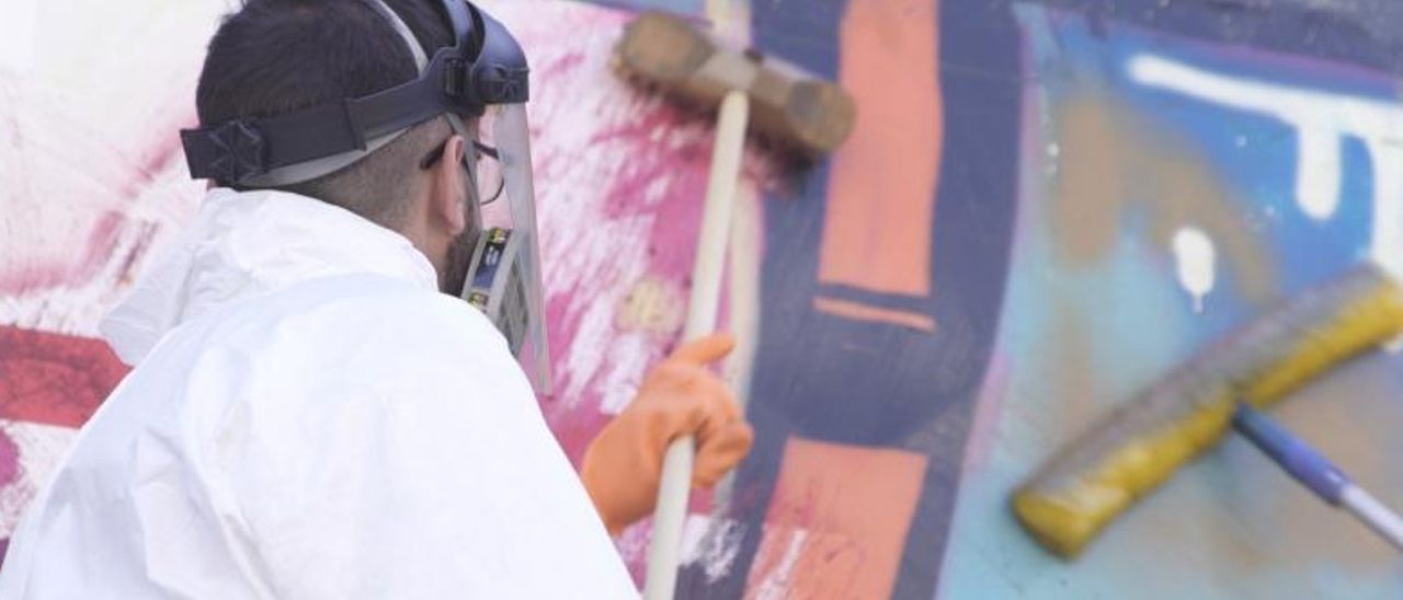 Un operario procede a limpiar un grafiti en un tren.