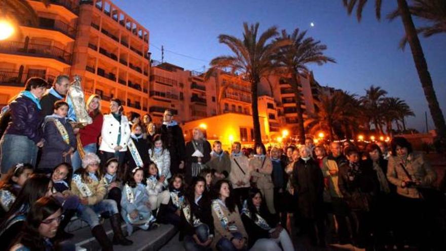 Imagen general de parte de la comitiva que acompañó ayer en procesión a la Virgen del Sufragio, cuando empezaba a romper el día, ante la playa de Poniente.