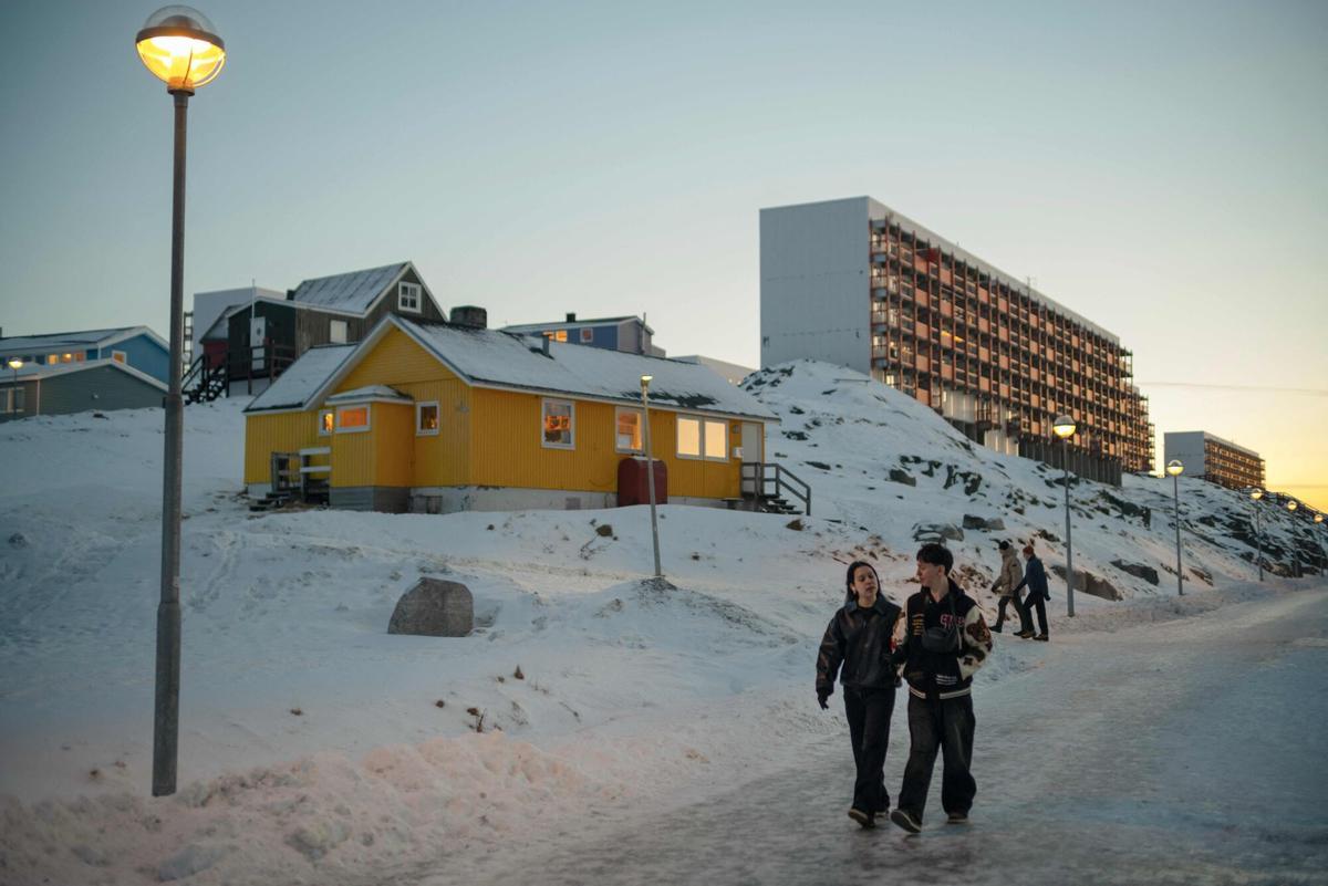 Una pareja pasea por las calles de Nuuk, capital de Groenlandia, que este enero registró su temperatura media más alta desde 1917.