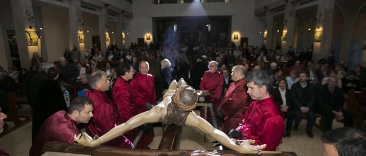 La siempre emotiva bajada del Cristo de la Buena Muerte, en la iglesia de Cristo Rey, que precede al vía crucis, uno de los muchos actos de la Semana Santa gandiense.