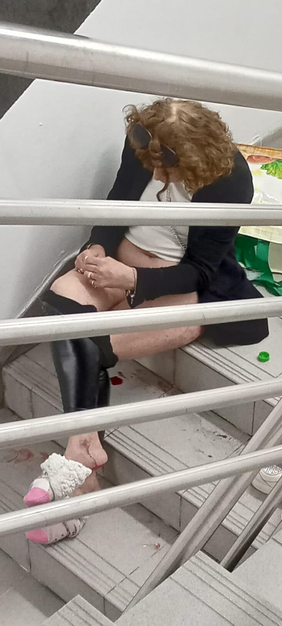 Una mujer en la escalera del aparcamiento con sangre.