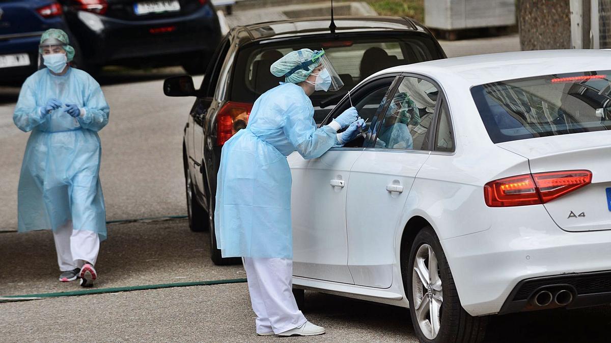 Dos sanitarias realizando pruebas PCR en el espacio “COVID-auto” del Provincial. |   // RAFA VÁZQUEZ