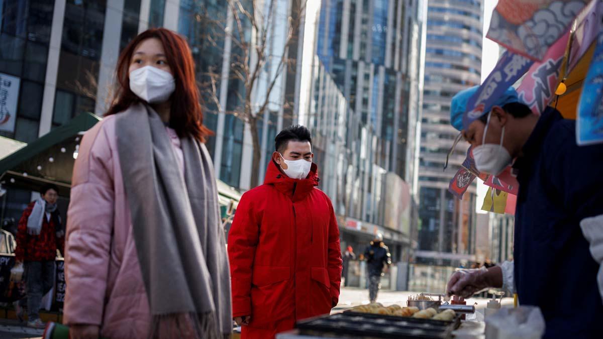 La gente compra comida callejera en un distrito comercial mientras China regresa al trabajo a pesar de los continuos brotes de la enfermedad por coronavirus (COVID-19) en Beijing.
