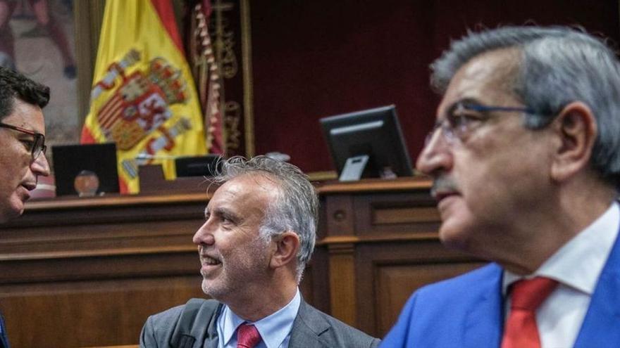 Román Rodríguez, junto a Ángel Víctor Torres, que charla con Pablo Rodríguez (CC) en el pleno del Parlamento. | Andrés Gutiérrez