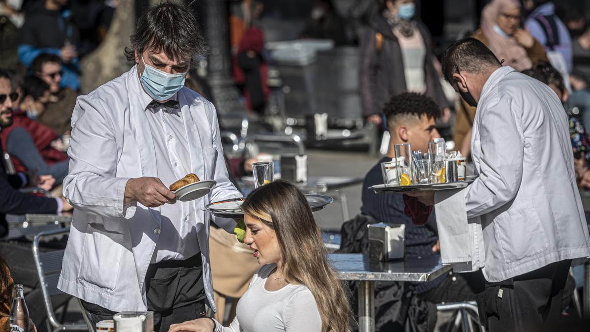 Camareros recogen la comida en una terraza de Barcelona.