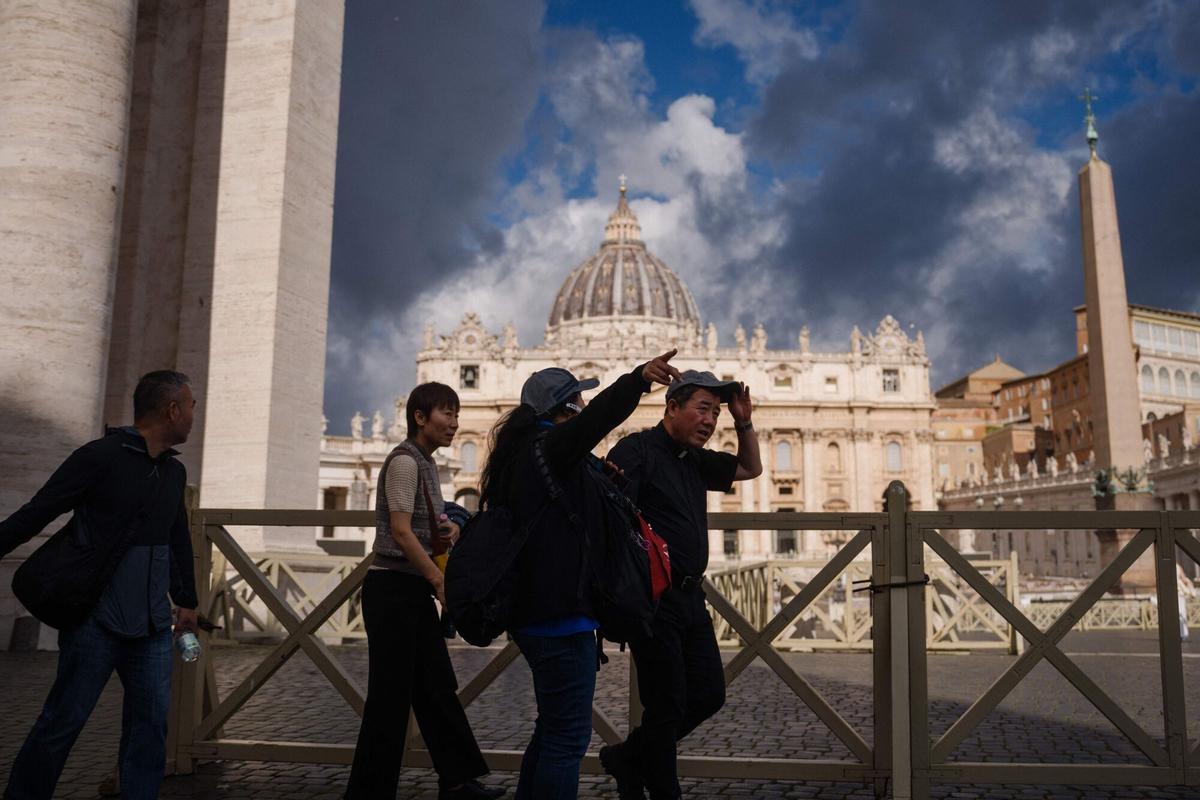 Visitors walk past St Peters Basilica at St Peters Square, a day prior to the start of the conclave, in the Vatican on May 6, 2025. (Photo by Dimitar DILKOFF / AFP)