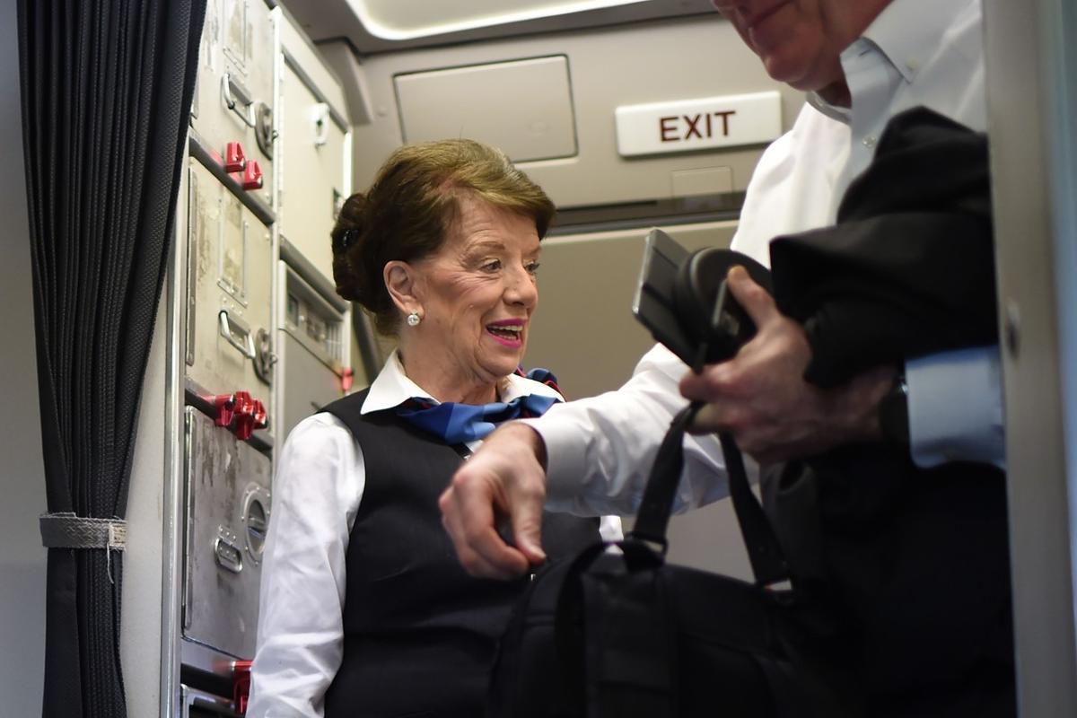 American Airlines longest serving flight attendant, Bette Nash (R), 81 years old, greets passengers disembarking from her daily return flight to Boston at Ronald Reagan Washington Airport in Arlington, Virginia on December 19, 2017.