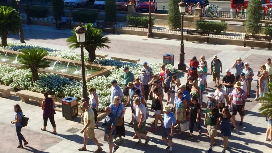 Un grupo de turistas pasea por la Glorieta de España de Murcia para dirigirse al entorno de la Catedral.