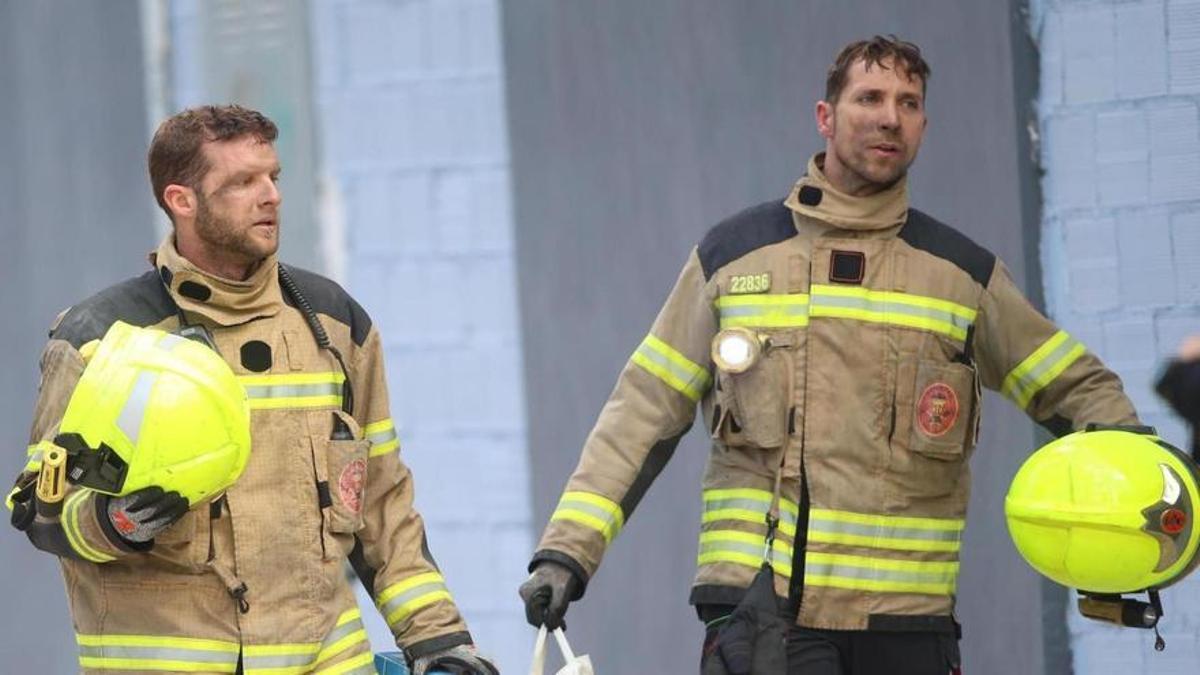 Dos bomberos recuperan un juego de Lego de un parque de bomberos de una vivienda del edificio incendiado de Campanar.