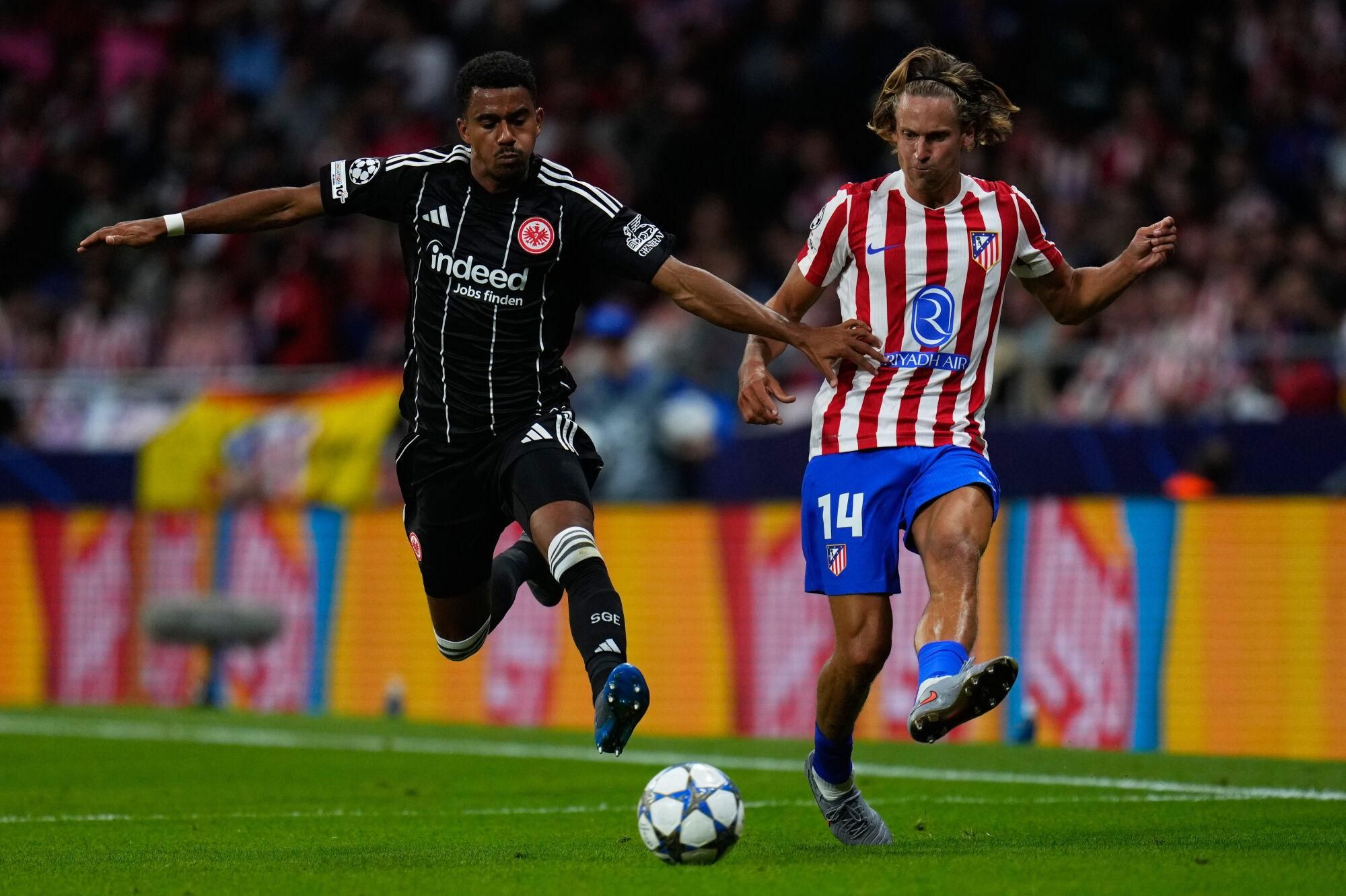 Frankfurt's Ansgar Knauff, left, and Atletico Madrid's Marcos Llorente challenge for the ball during the Champions League opening phase soccer match between Atletico Madrid and Eintracht Frankfurt at the Metropolitano stadium in Madrid, Spain, Tuesday, Sept. 30, 2025. (AP Photo/Manu Fernandez). Editorial use only / Only Italy and Spain