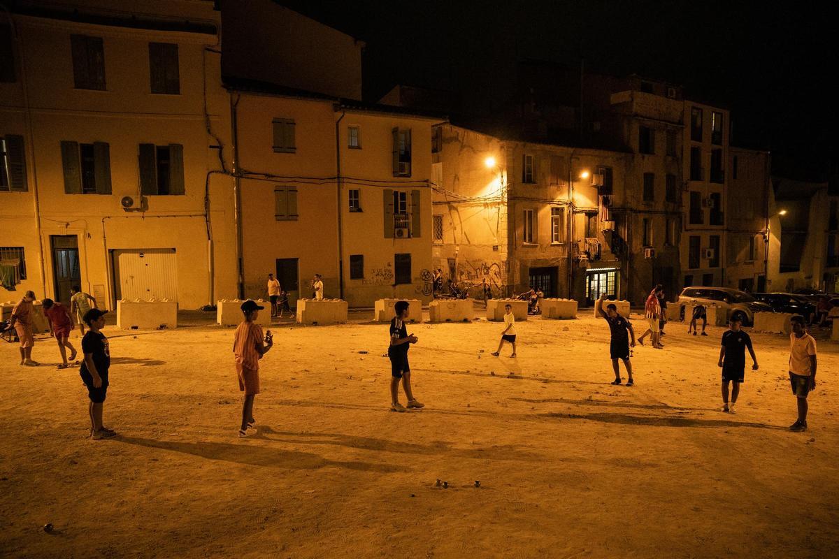Niños jugando de noche en el barrio de Sant Jaume