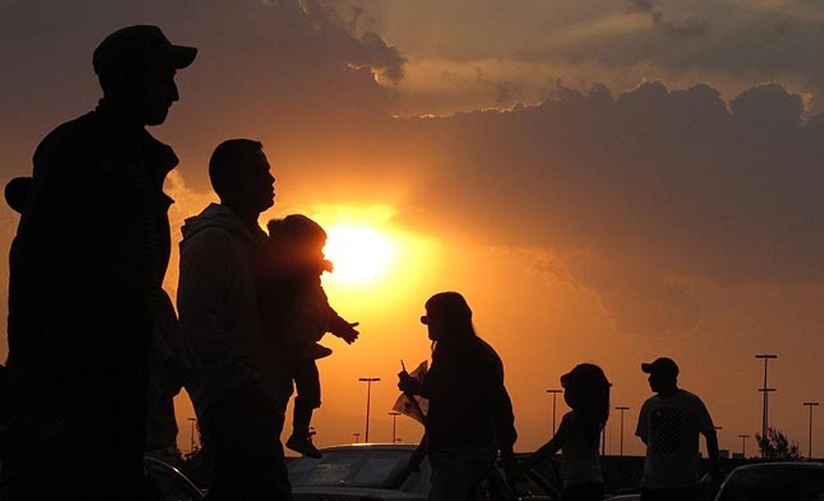 Algunes persones caminen en un carrer de la ciutat de Mèxic durant el capvespre.