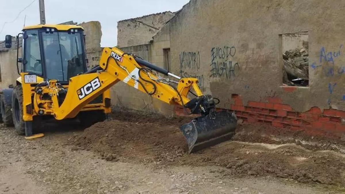 Un operario con una excavadora trabaja en una de las calles del pueblo.