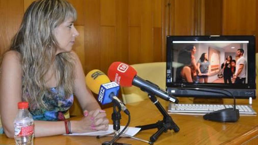 La edil de Relaciones con las Universidades viendo el video promocional.