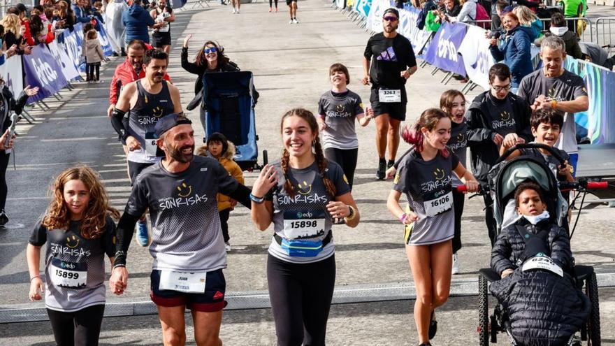 Pedro y Mario, a la derecha,  cruzan la meta con los corredores de Empujando Sonrisas. |  // LOC