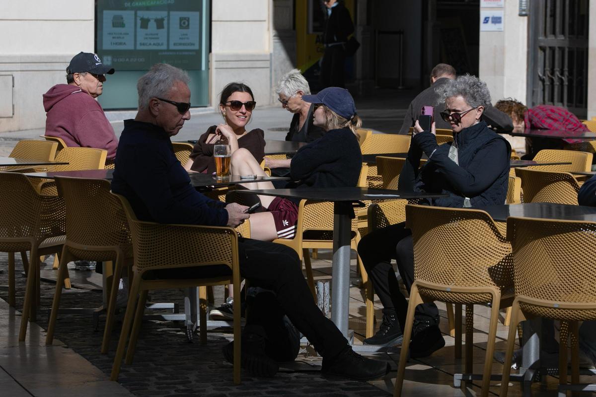 Una pareja de mayores, sentada en una terraza de Cartagena mientras miran sus móviles, este jueves.