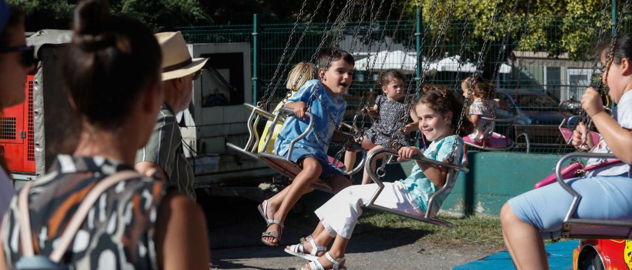 Niños subidos al tiovivo (arriba) y varias personas entrando en el recinto ferial. | Mara Villamuza