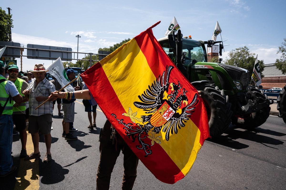 Un manifestante hace ondear una bandera austracista parecida a la franquista en la llegada de tractores a Madrid en la protesta del pasado 5 de julio.