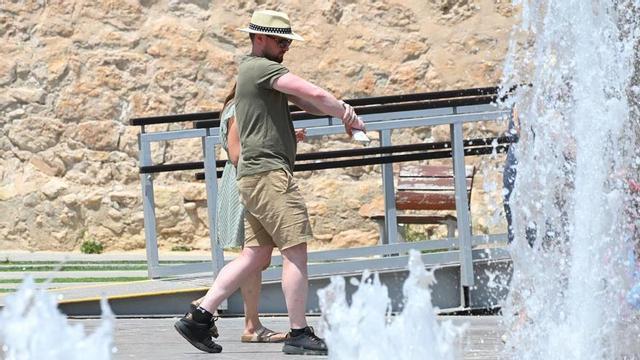 Un home passeja al costat d’una font a Alacant.