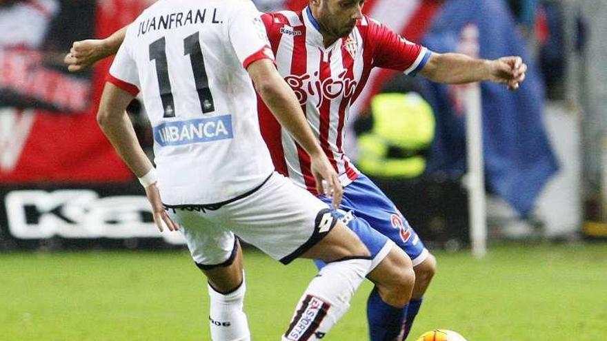 Juanfran presiona a Jony anoche en El Molinón.