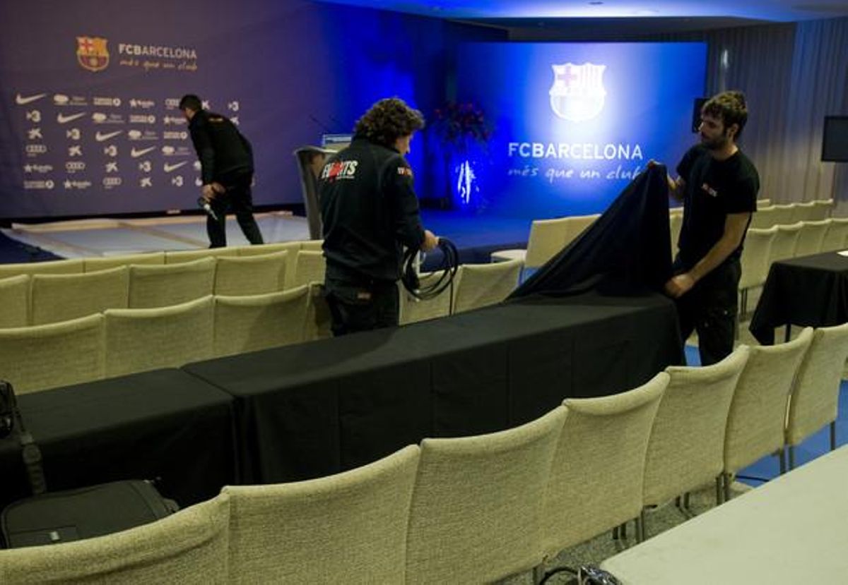 Operaris desmunten l’escenari de la sala del Camp Nou on s’havia de celebrar la roda de premsa de Sandro Rosell, aquest matí.