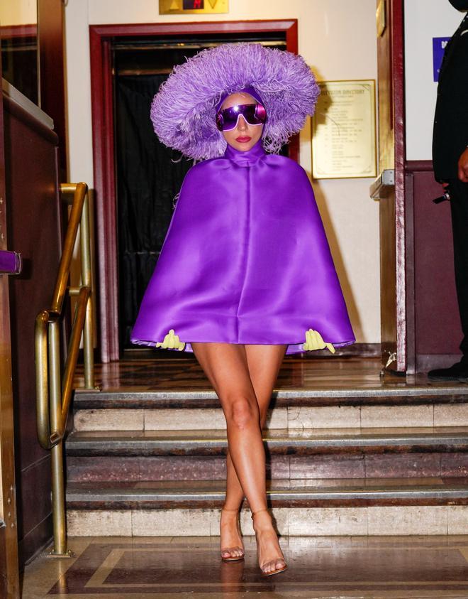 Lady Gaga con un vestido morado y sombrero de plumas de avestruz