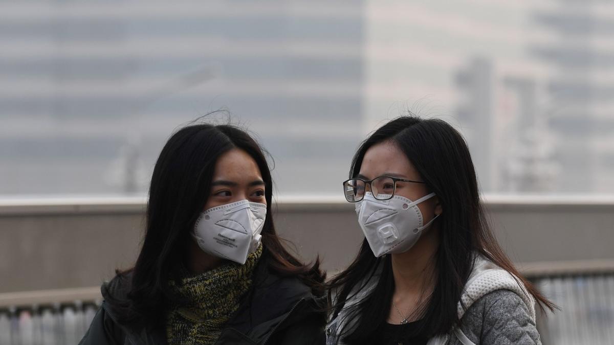 Dos chicas se protegen de la contaminación en Pekín el pasado lunes.