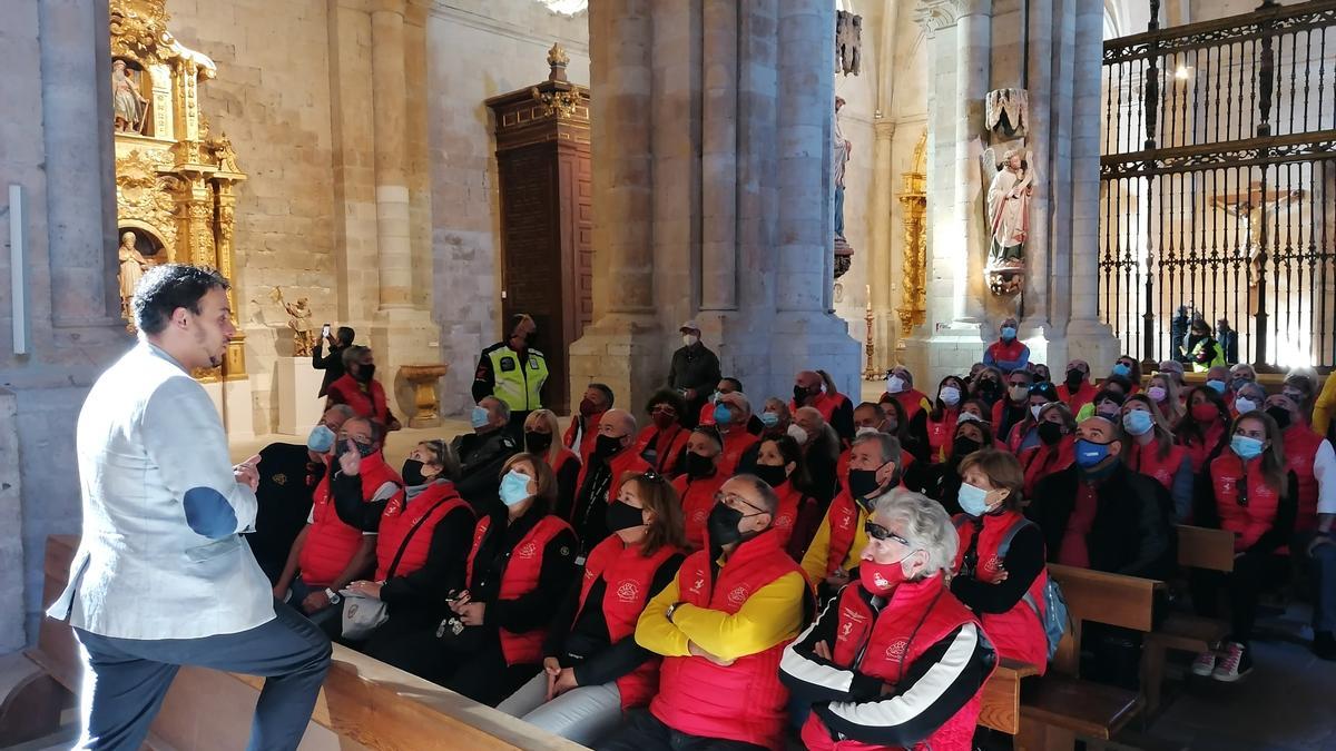 Tomás del Bien, de pie, explica a los participantes en la concentración los tesoros que custodia La Colegiata