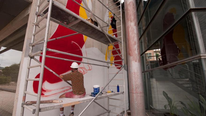 El artista EMEA realiza la pintura mural en el teatro de Lloseta.