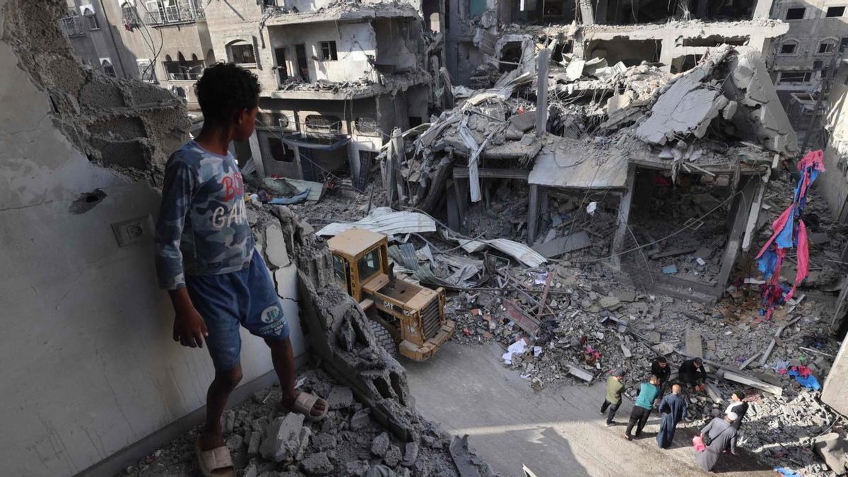 Un nen palestí observa un edifici destruït ahir durant un atac d’Israel al camp de refugiats de Maghazi, al centre de la Franja de Gaza. | EIAD BABA / AFP