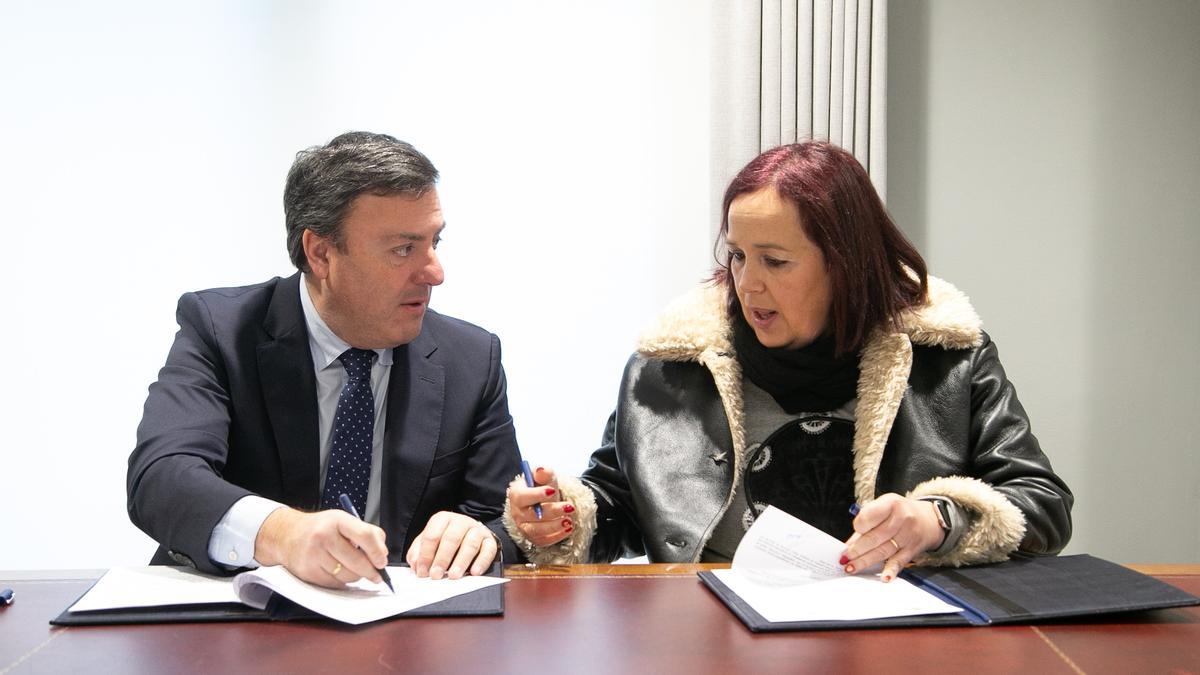 Valentín González e Sandra Insua asinando o convenio.