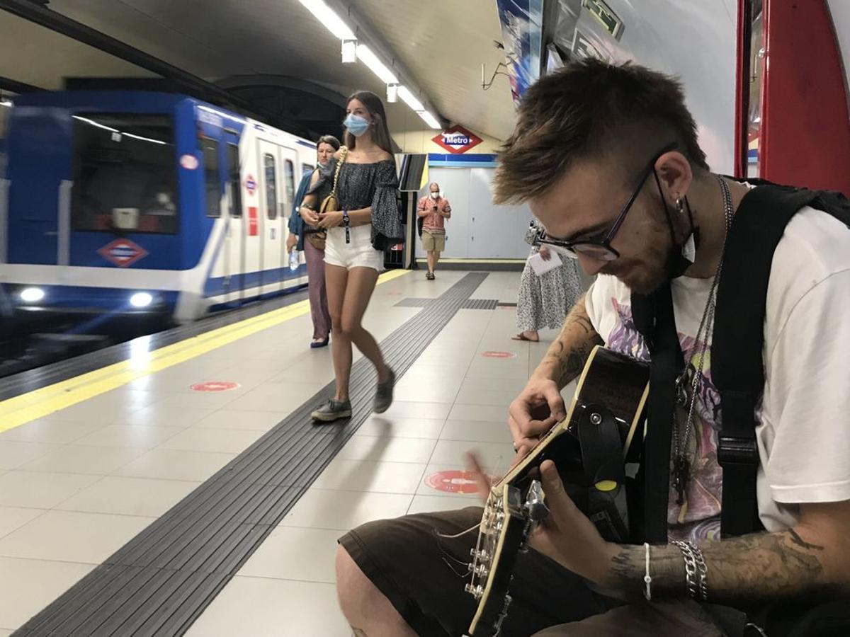 Un músico callejero toca en una estación de Metro de Madrid
