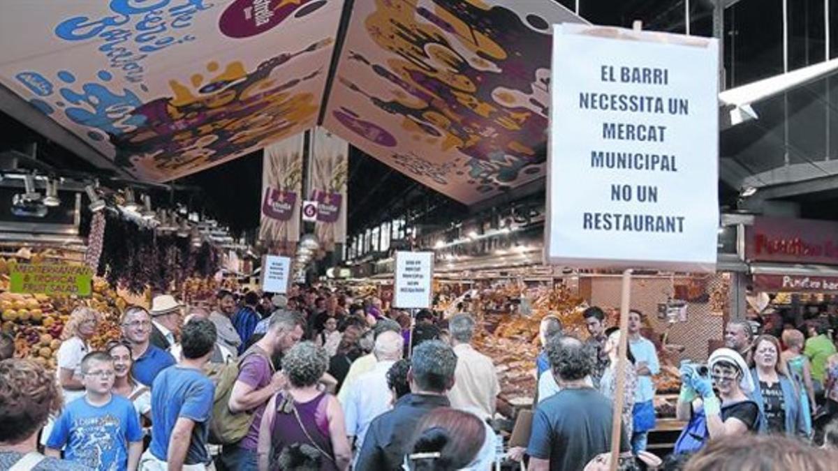 Protesta en la Boqueria 8 Un grupo de barceloneses, ayer, porta pancartas contra la reconversión de la instalación por el turismo masivo.