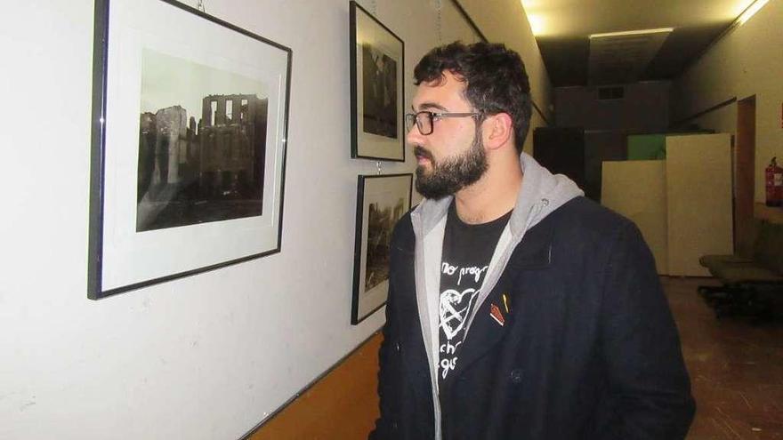 Alejandro Fernández observa una de las fotografías de la exposición &quot;Cangas bajo las bombas&quot;.