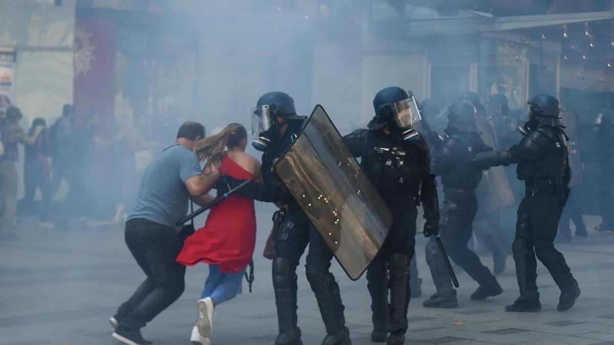 Manifestantes huyen del gas lacrimógeno, en la manifestación de los 'chalecos amarillos' en París