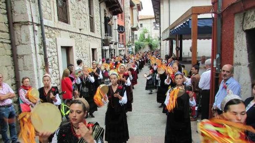 Las aldeanas tocan la pandereta a su paso por la calle Mayor en la fiesta de 2017.
